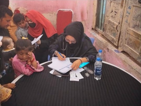 A doctor consulting patients at a free community medical camp run by Ahmed Hospital